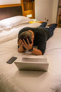 High angle view of woman sitting on bed at home