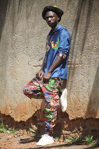 Young man standing against wall