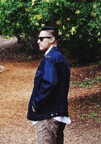 Side view of young man standing in park