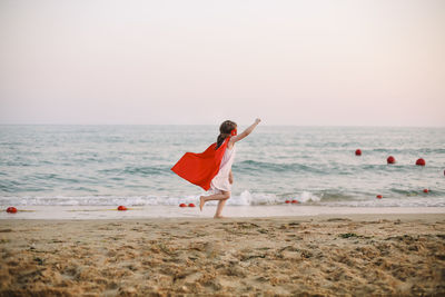 Side view of girl running on beach