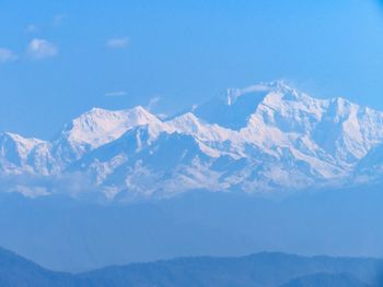 Scenic view of snowcapped mountains against blue sky