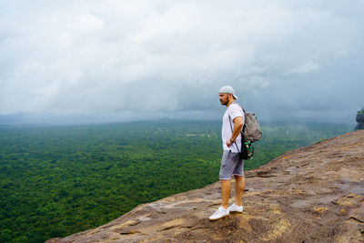 Pidurangala rock. sri lanka. young man looks on the landscape.