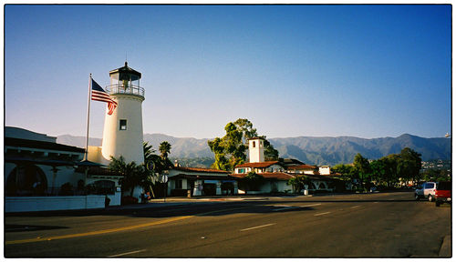 Road leading to built structure against clear blue sky