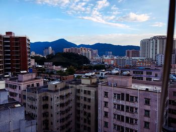 Residential district by mountains against sky