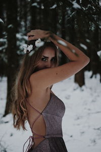 Portrait of young woman standing in snow