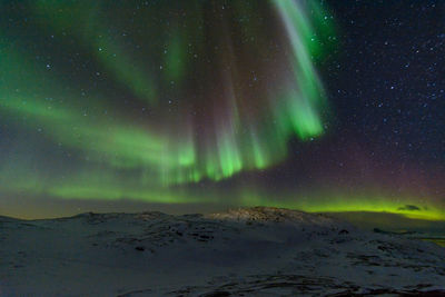 Scenic view of snowy landscape against sky at night