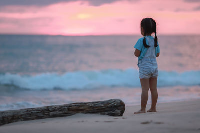 Full length of girl standing at beach during sunset