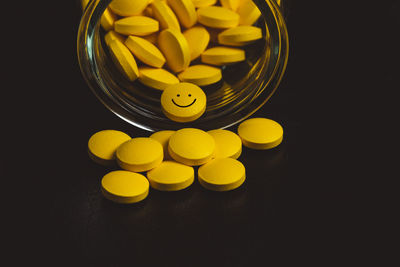 Close-up of yellow bottle against black background