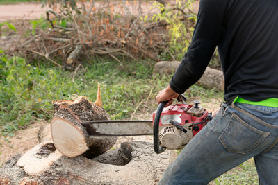 Man cutting log with chainsaw