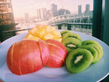 Close-up of fruits in plate by window