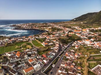 High angle view of buildings and sea against clear sky