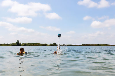 Man surfing in sea against sky