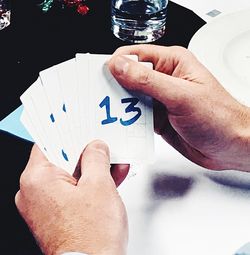 Close-up of man holding hands on table