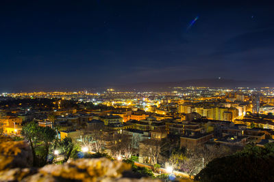 High angle view of illuminated cityscape against sky at night