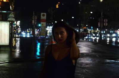 Portrait of man standing on street at night