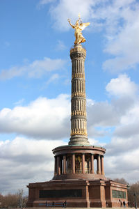Low angle view of brandenburg gate against cloudy sky