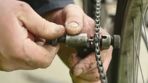 Cropped image of man fixing bicycle chain