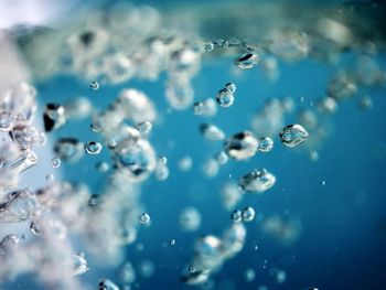 Close-up of bubbles against blue water