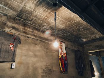 Low angle view of illuminated lights hanging on ceiling in building