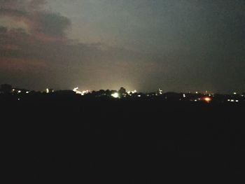 Illuminated city against sky at night