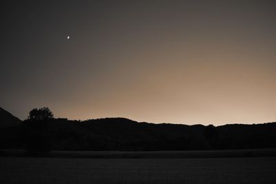 Scenic view of silhouette field against sky at night