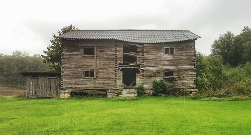 Old house on field against sky