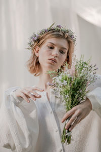 Portrait of a beautiful young woman holding flower