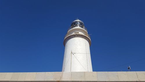 Low angle view of lighthouse against clear blue sky