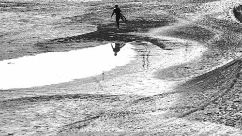 Silhouette surfer walking on beach