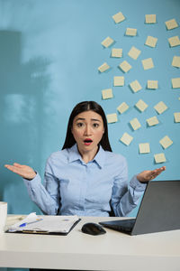 Portrait of young businesswoman using digital tablet while sitting on table