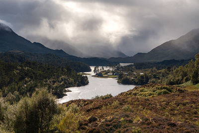 Scenic view of river amidst mountains against sky