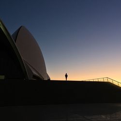 Low angle view of silhouette woman standing against clear sky