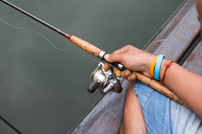 Midsection of man holding fishing rod