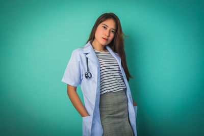 Portrait of a young woman against blue background