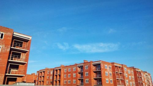 Low angle view of residential buildings against blue sky