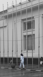 Man walking on street against building