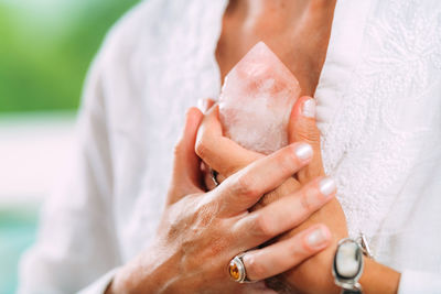 Self-worth meditation. hands holding a rose quartz crystal, meditating, improving a sense 