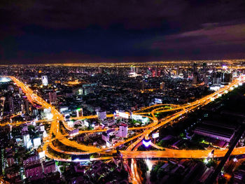 High angle view of illuminated city against sky at night