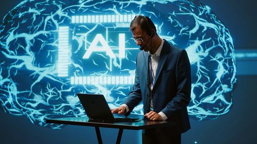 Portrait of businessman using laptop at office