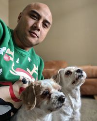 Portrait of man with dogs at home