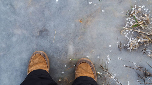 Low section of man standing by water