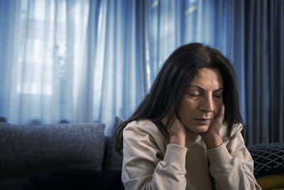 Depressed woman sitting in living room