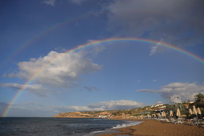 Scenic view of rainbow over sea against sky