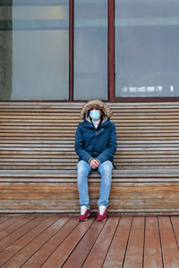 Full length of man sitting outdoors