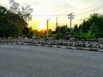 Bridge by road against sky during sunset