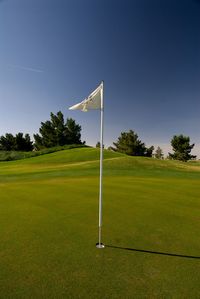 Scenic view of golf course against sky