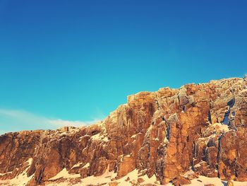 Rock formations against clear blue sky