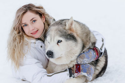 Portrait of woman with dog in snow