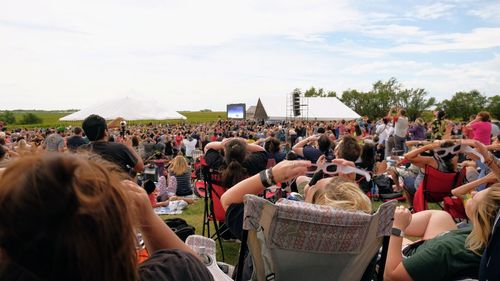 Crowd at music concert against sky