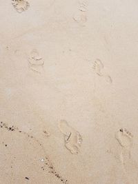 Close-up of footprints on sand at beach